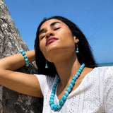 Woman wearing  Larimar Necklace jewelry against a clear blue sky
