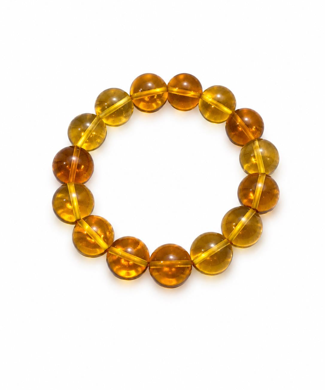 A beaded stretch bracelet made of translucent Dominican
amber beads in warm golden-yellow and orange-brown tones, photographed on a plain white background.