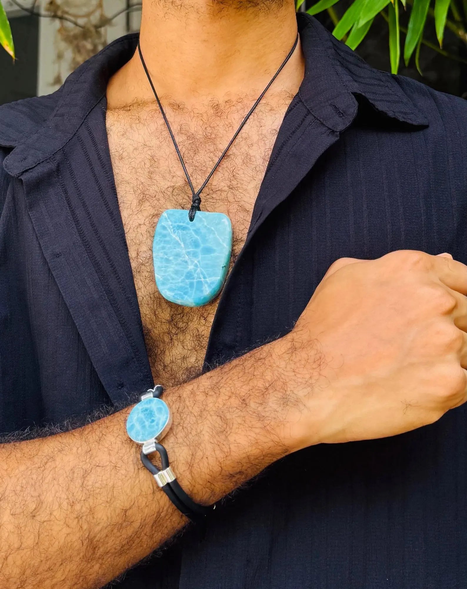 a man wearing a larimar stone bracelet and necklace