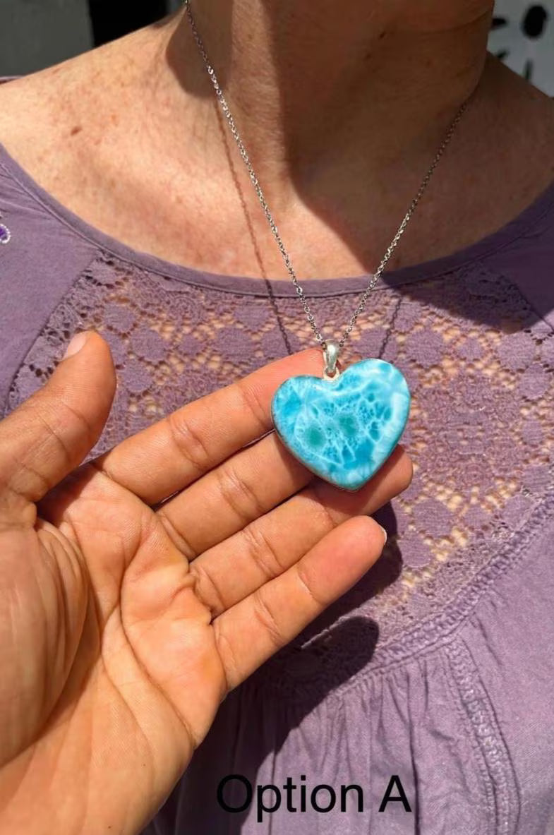 A woman wearing a Larimar Heart Pendat Blu necklace