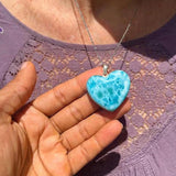 A woman wearing a Larimar Heart Pendat Blu necklace