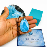 A hand holding a larimar necklace