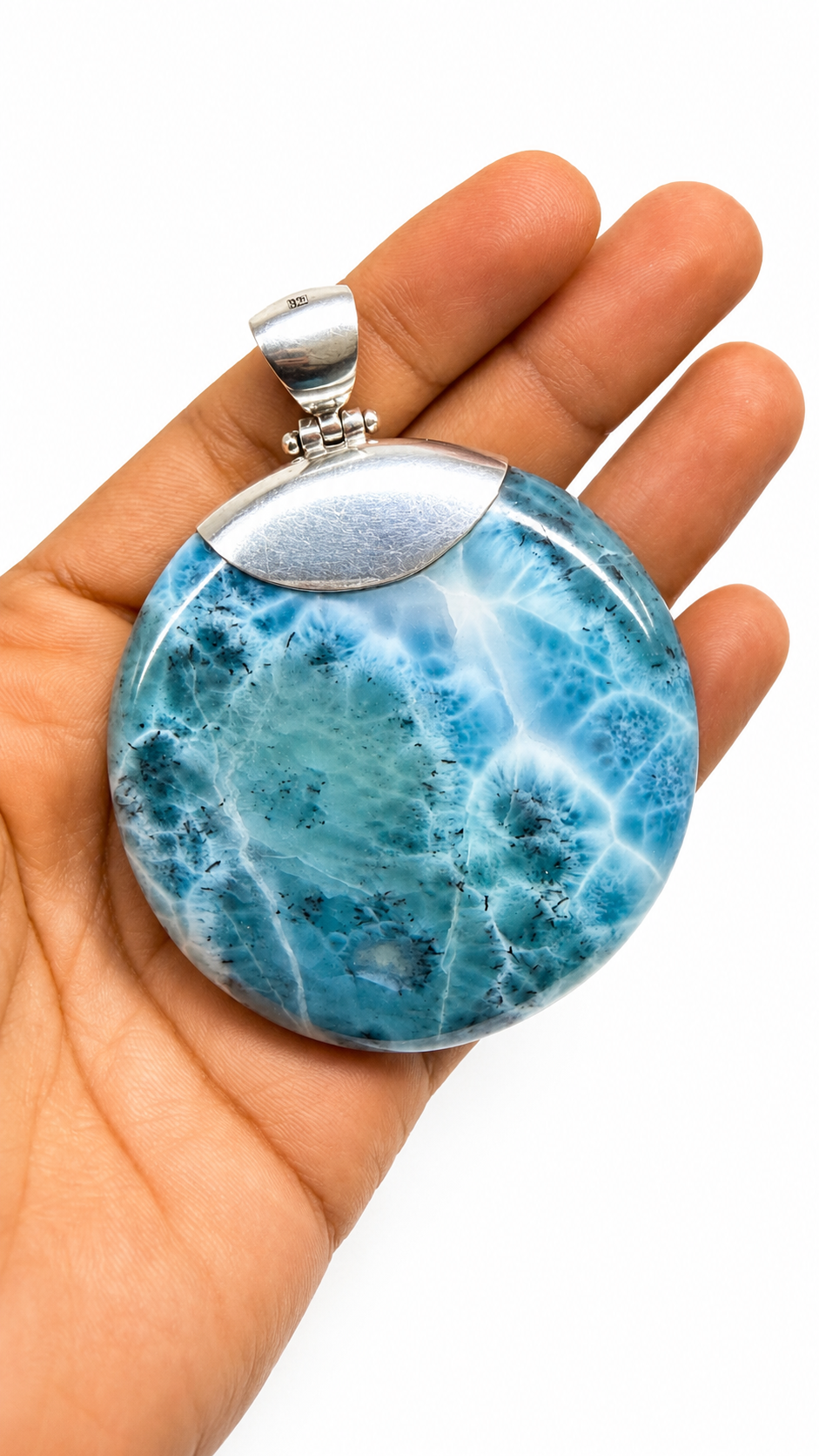 AAA Larimar round cabochon pendant in hand – deep ocean-blue with white fractal starburst pattern – genuine Dominican Republic gemstone
