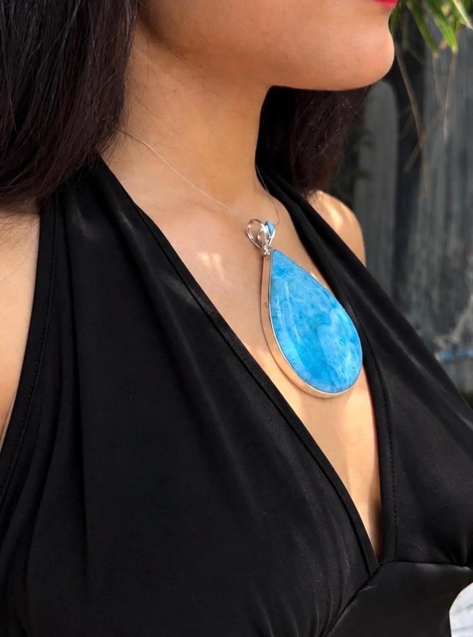 A woman wearing a high grade larimar necklace pendant 