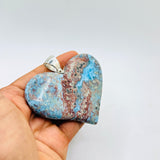 A hand holding a big Larimar Pendant