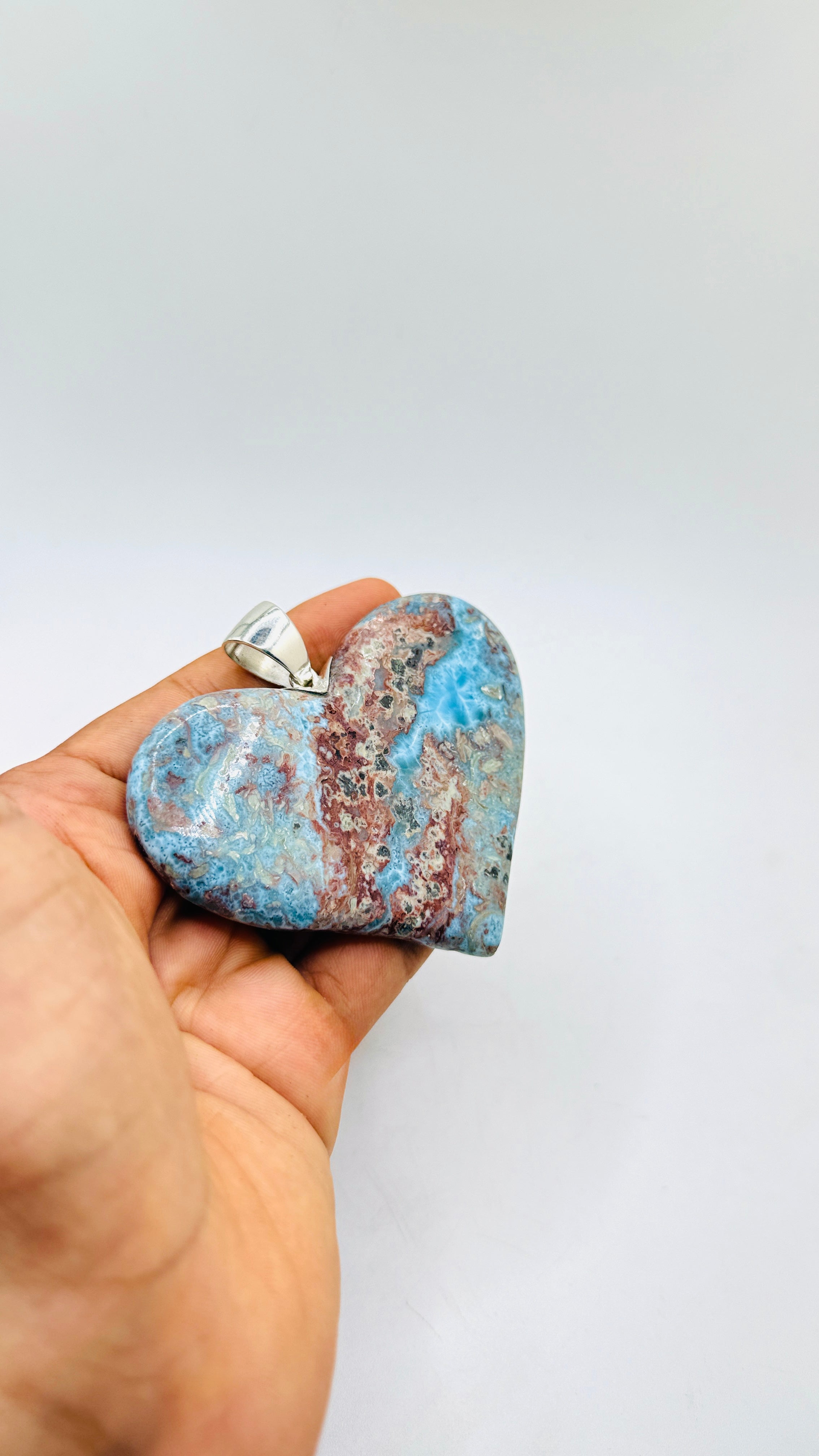 A hand holding a big Larimar Pendant