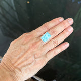 a hand wearing a larimar ring