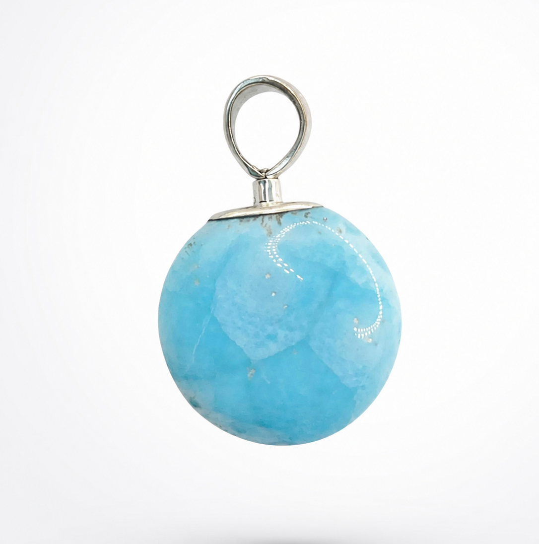 A round light blue stone pendant with a silver metal loop and cap, shown against a plain white background.
