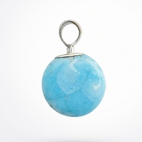 A round light blue stone pendant with a silver metal loop and cap, shown against a plain white background.