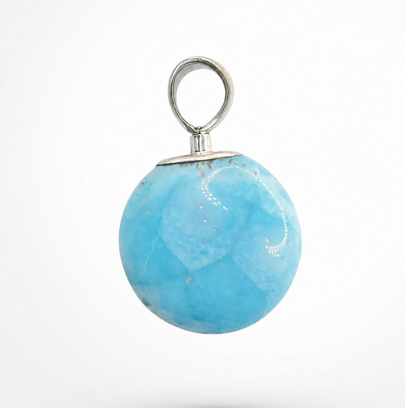A round light blue stone pendant with a silver metal loop and cap, shown against a plain white background.