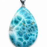 A teardrop-shaped larimar gemstone pendant with a vibrant blue and white marbled pattern, featuring a silver bail at the top, set against a plain white background.