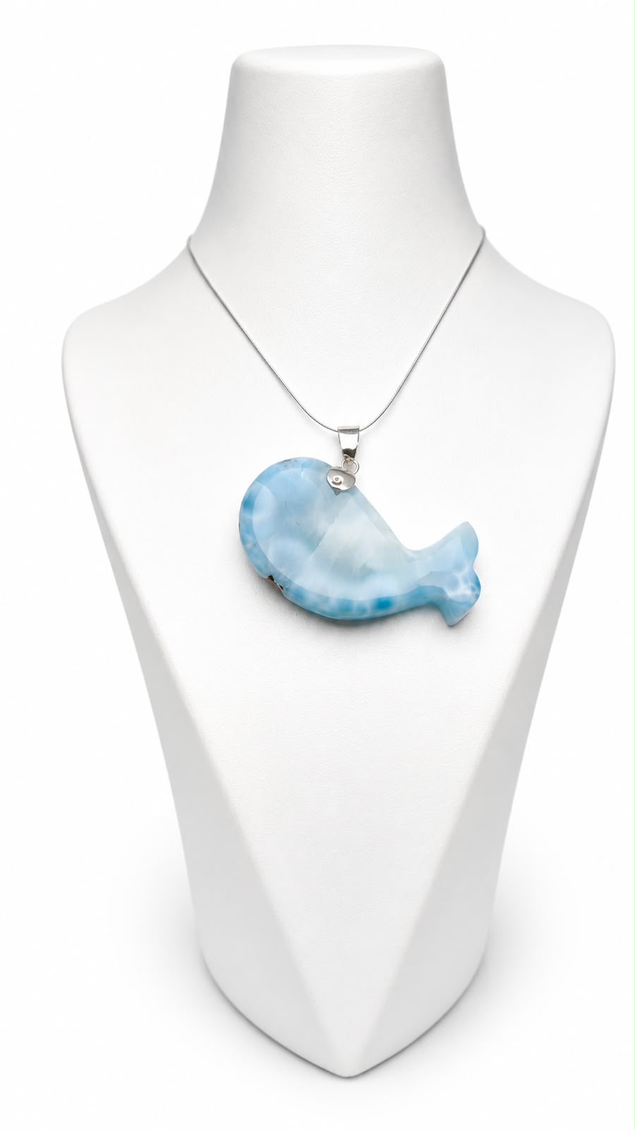 A silver necklace with a light blue and white marbled whale-shaped pendant, displayed on a white mannequin bust against a white background.