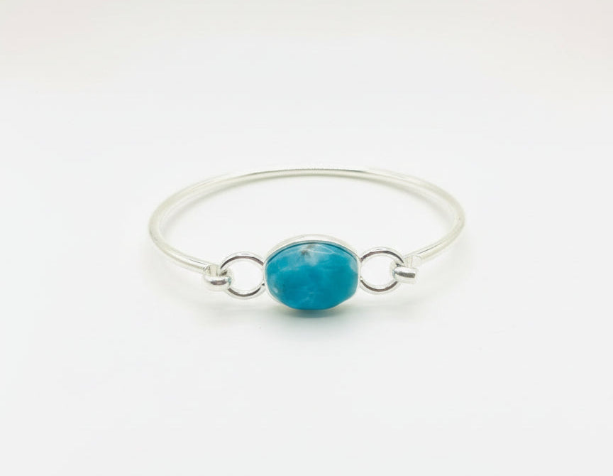 Turquoise stone with silver ring on a white background