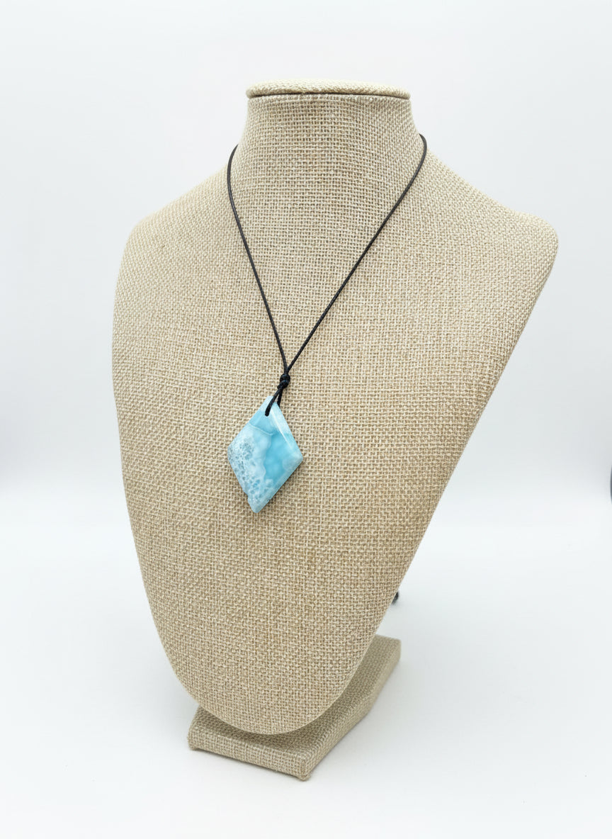 Larimar Necklace with a blue pendant on a mannequin bust outdoors.