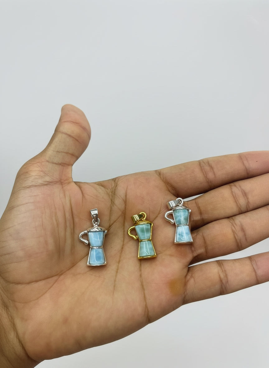 a hand holding larimar pendants
