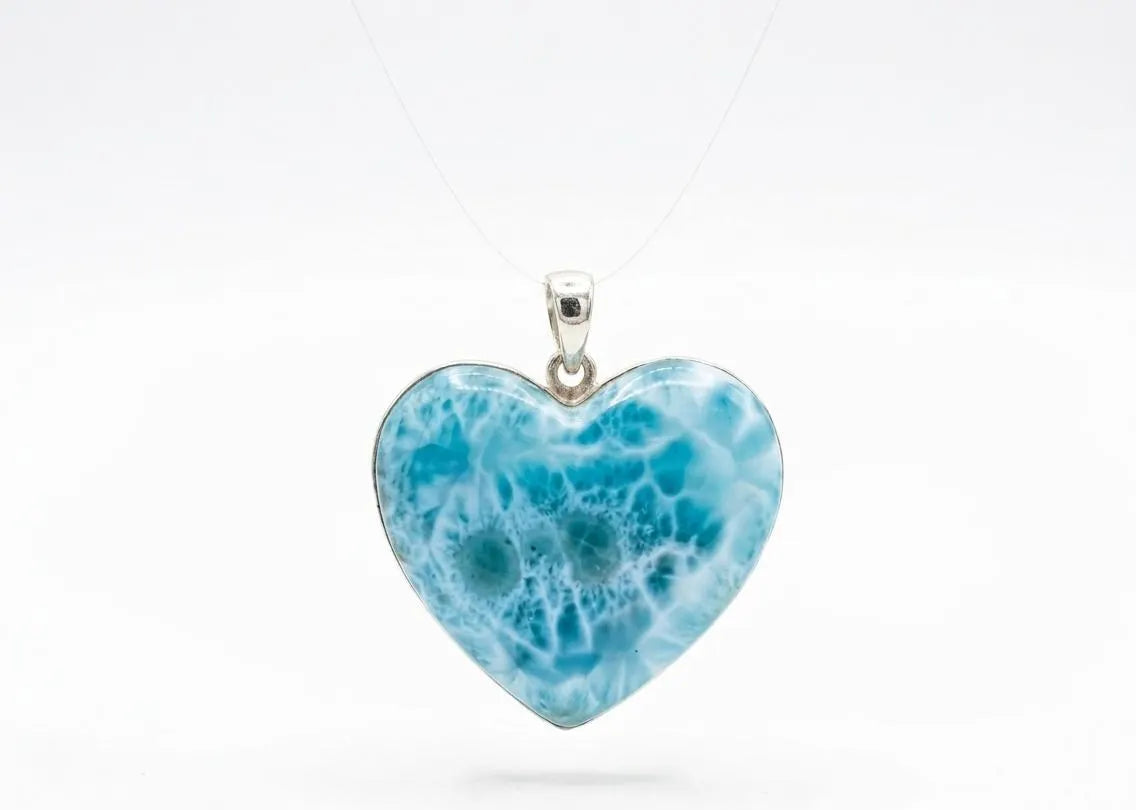 Heart-shaped blue pendant on a white background