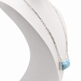 Necklace with a larimar pendant on a white mannequin bust