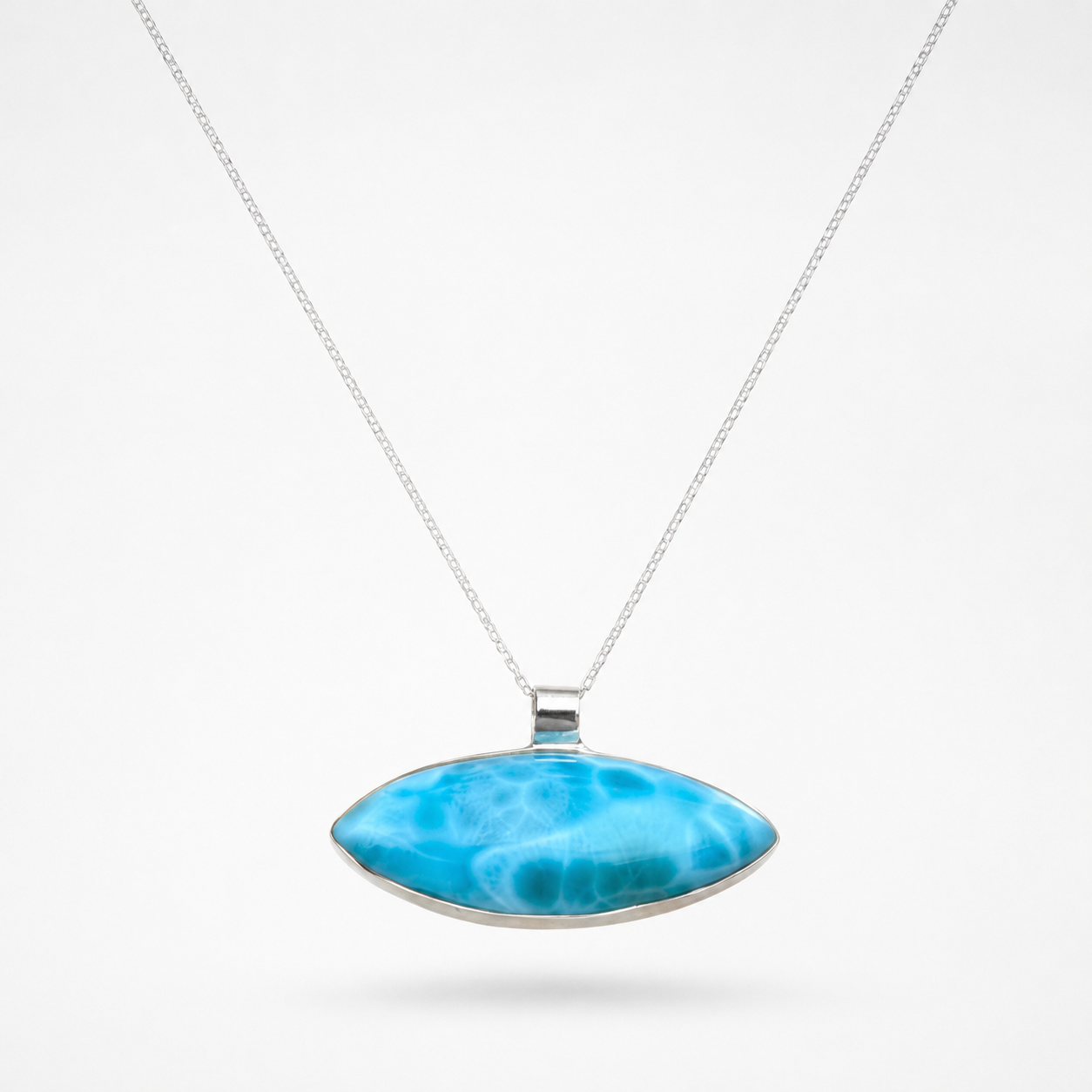 A silver Larimar pendant necklace featuring a horizontally oriented, teardrop-shaped Larimar stone with vibrant blue and white marbled patterns, suspended from a delicate silver chain against a clean white background.