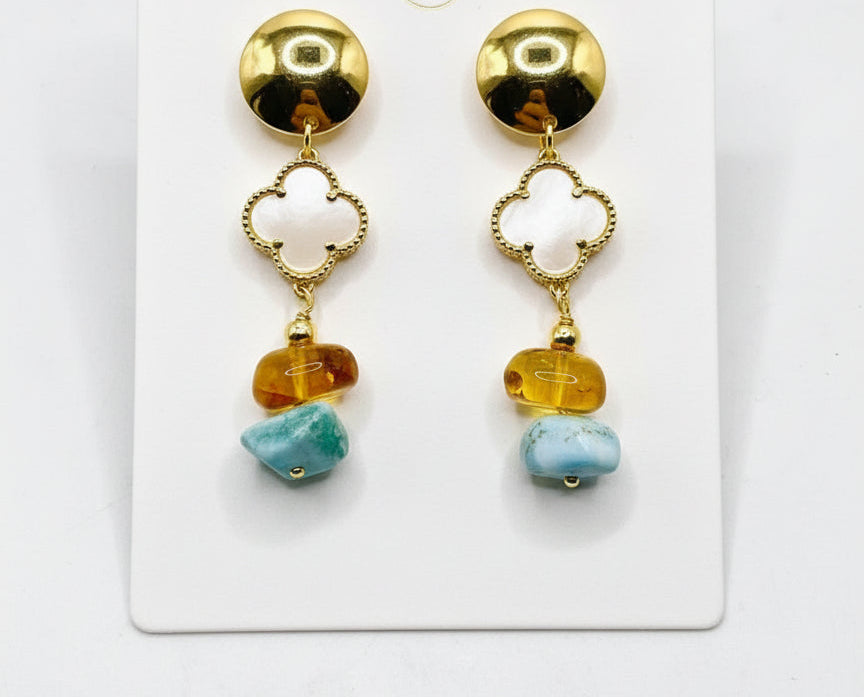 Pair of gold earrings with colorful beads on a white card