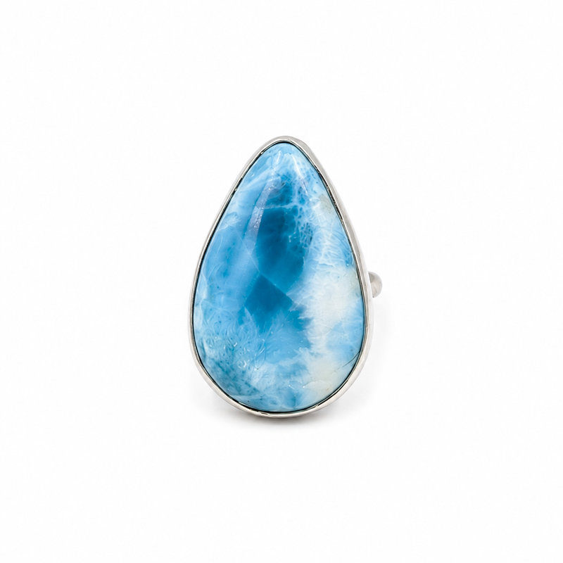 A teardrop-shaped Larimar ring featuring a vibrant blue marbled stone in a silver bezel setting, shown against a plain white background.