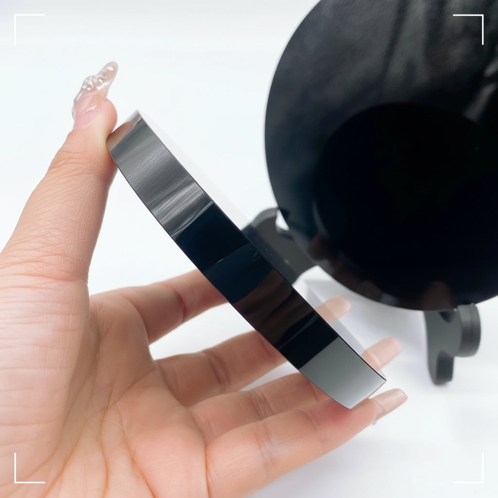 Hand holding a black and silver tool against a white background