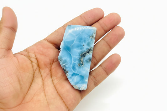 Hand holding a blue marbled stone in a store setting