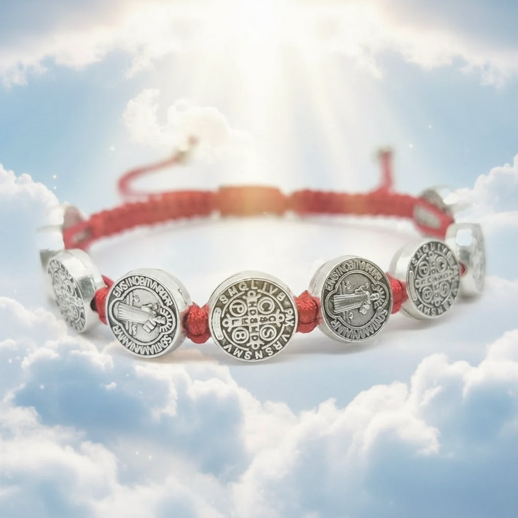 Bracelet with red cord and silver charms on a white background