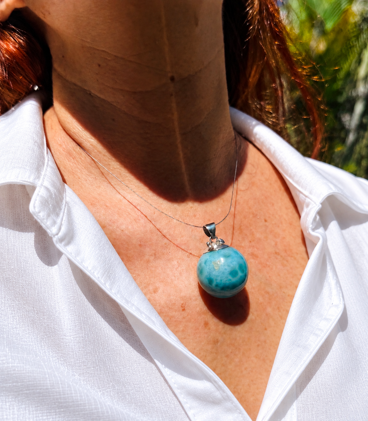 a woman wearimg a larimar bead necklace