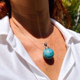 a woman wearimg a larimar bead necklace