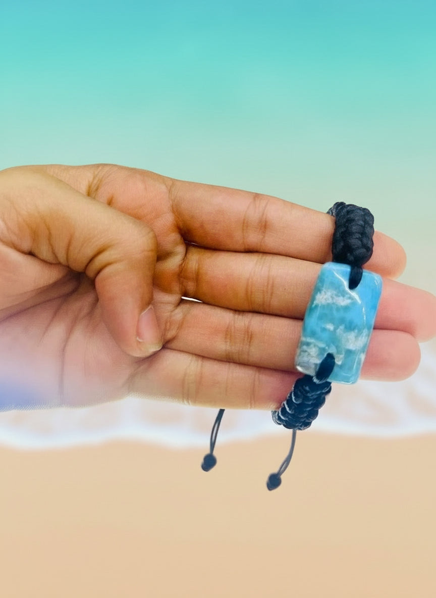 Hand holding a blue beaded bracelet with a blurred background