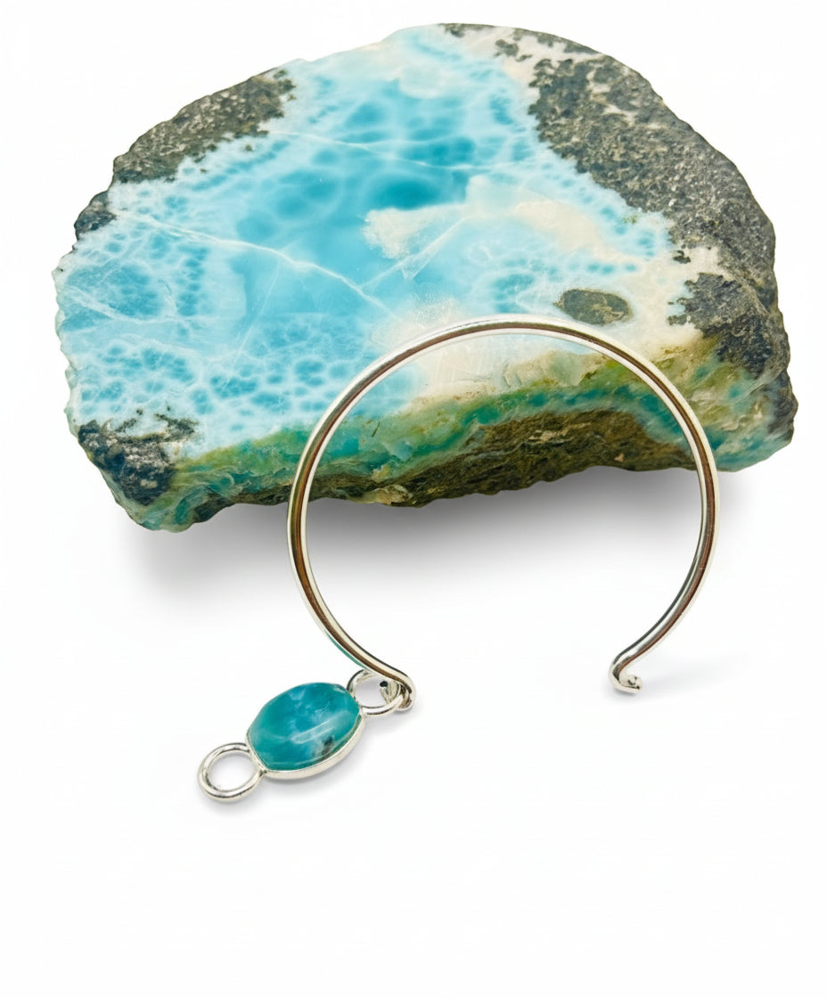 Silver bangle with a turquoise stone on a rock background