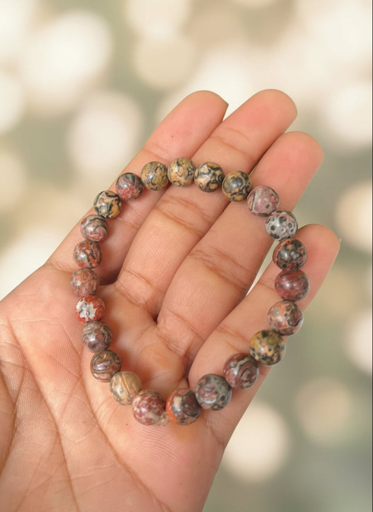 Hand holding a beaded bracelet with a natural background