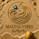 Mauna Vibes logo on sand with a coconut and blue stone Larimar Dominican Republic